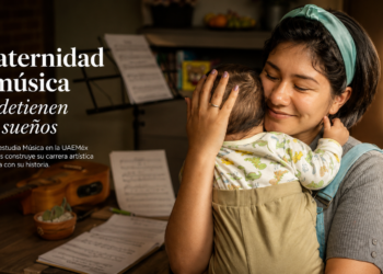 Entre ensayos, tareas universitarias, partituras y noches de desvelo, Daleth aprendió a dividir su tiempo entre la música y la crianza de su hijo. Apenas dos meses después de convertirse en madre, regresó a las aulas de la Universidad Autónoma del Estado de México (UAEMéx) decidida a no abandonar ninguno de sus sueños. A sus 25 años, Daphne Alitzel Sánchez Weichselbaum —conocida artísticamente como Daleth— cursa el cuarto semestre de la Licenciatura en Música en la Escuela de Artes Escénicas, mientras construye una carrera artística marcada ahora por una experiencia que transformó profundamente su vida y su manera de crear. “Tenía miedo, claro, porque la vida cambia totalmente, pero también sentía que era algo que quería vivir”, recuerda. Originaria de la Ciudad de México y criada entre Metepec y San Mateo Atenco, Daleth descubrió desde niña su pasión por la música. Antes de ingresar profesionalmente al mundo artístico, cantaba en camiones y negocios de comida para perder el miedo al rechazo y fortalecer su seguridad frente al público. Con el tiempo aprendió a tocar instrumentos como guitarra, ukelele y armónica, hasta ingresar al conservatorio como guitarrista clásica y posteriormente continuar su formación universitaria en la UAEMéx. Sin embargo, mientras consolidaba su proyecto musical, enfrentó uno de los retos más complejos de su vida: combinar la maternidad con las exigencias físicas, emocionales y académicas de una carrera artística. Junto a su esposo decidió conscientemente convertirse en madre, aun sabiendo que el proceso implicaría transformar por completo sus rutinas, prioridades y dinámicas personales. La llegada de su hijo, Naím León, modificó su vida diaria. Entre clases, ensayos y cuidados maternos, tuvo que reorganizar su tiempo para continuar perfeccionando su técnica vocal y ampliar sus conocimientos en composición musical. Durante ese proceso encontró apoyo dentro de la comunidad universitaria. Compañeras y compañeros que la ayudaban a cargar materiales, docentes atentos a sus necesidades y la creación de un lactario en la Escuela de Artes Escénicas marcaron positivamente su experiencia como estudiante y madre primeriza. Pero la maternidad no solo transformó su vida cotidiana; también cambió profundamente su sensibilidad artística. “Cuando lo tuve en mis brazos, algo se desbloqueó en mí. El amor que siento ahora por todo, las ganas, la motivación; él es mi todo. Mi fuerza, mi tierra, mi luz”, comparte. Esa experiencia inspiró “Mi Todo”, su primer sencillo musical, una canción dedicada a su hijo cuyo lanzamiento está previsto para este verano. El videoclip del tema también se desarrolla en colaboración con estudiantes de la Licenciatura en Estudios Cinematográficos de la propia UAEMéx. Actualmente, Daleth continúa construyendo su proyecto artístico mientras avanza en su formación profesional, convencida de que la maternidad y la música no son caminos opuestos. Sus metas van más allá de convertirse en cantante. También busca desarrollarse como compositora para cine, teatro y proyectos audiovisuales. “Quiero que mi música conecte con otros, que sea la voz que otras personas no encuentran en ese momento”, afirma. Entre canciones, ensayos universitarios y la crianza de su hijo, Daleth construye una historia donde la maternidad no significa detener los sueños, sino encontrar nuevas razones para seguir creando.